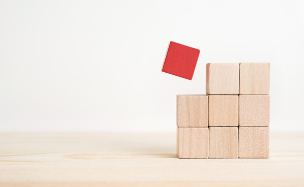 9 wooden cubes stacked as 3 by 3 of which one is red.