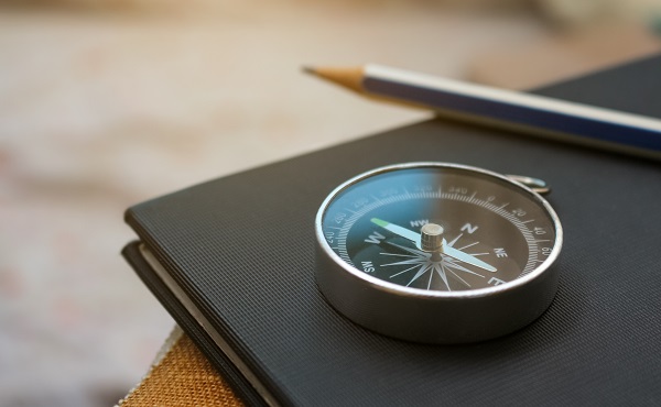 A compass laid on the black table.