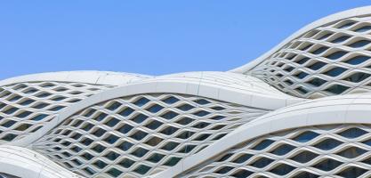 A wavy exterior of a building with grid windows.